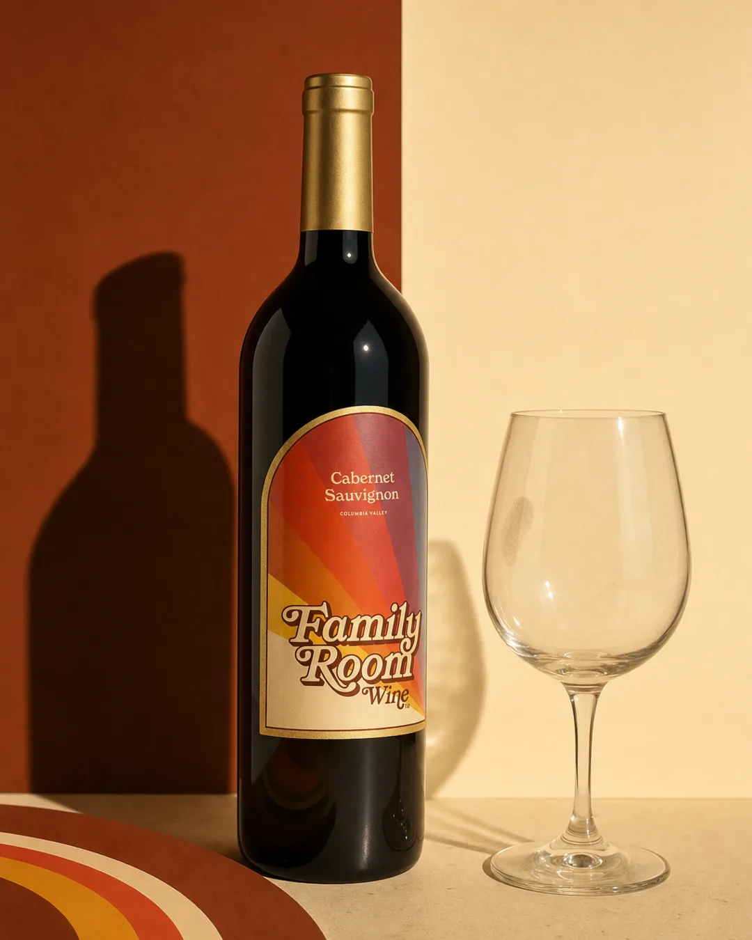 Cabernet bottle and glass against a split chestnut and cream studio backdrop