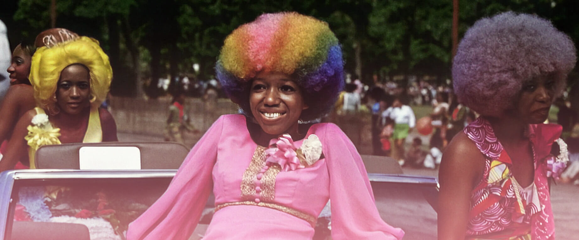 Friends celebrating at a Pride parade in brightly colored outfits